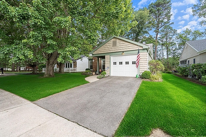 View of front of home featuring driveway, a front yard, and stone siding