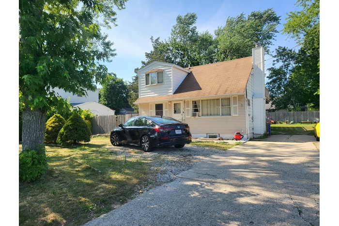 View of front of house featuring a chimney and a shingled roof