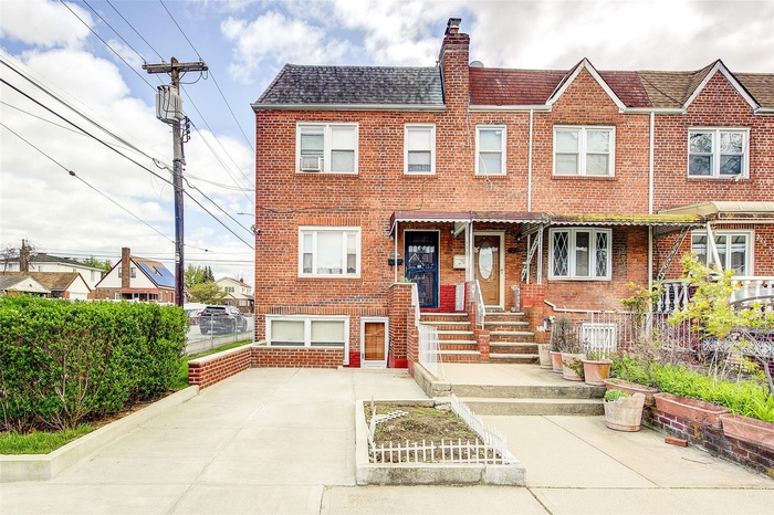 Multi unit property with fence, a chimney, and brick siding