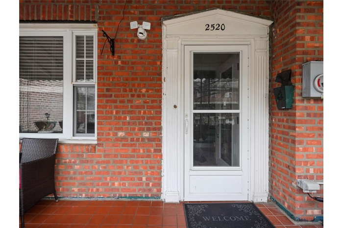 Entrance to property featuring brick siding