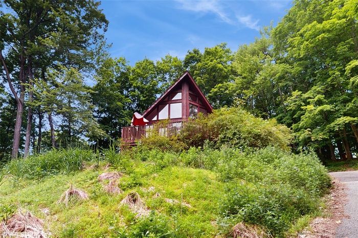 View of home's exterior featuring a wooden deck and chalet windows