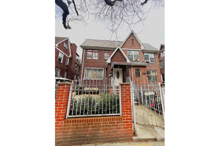 View of front of home with a fenced front yard and brick siding