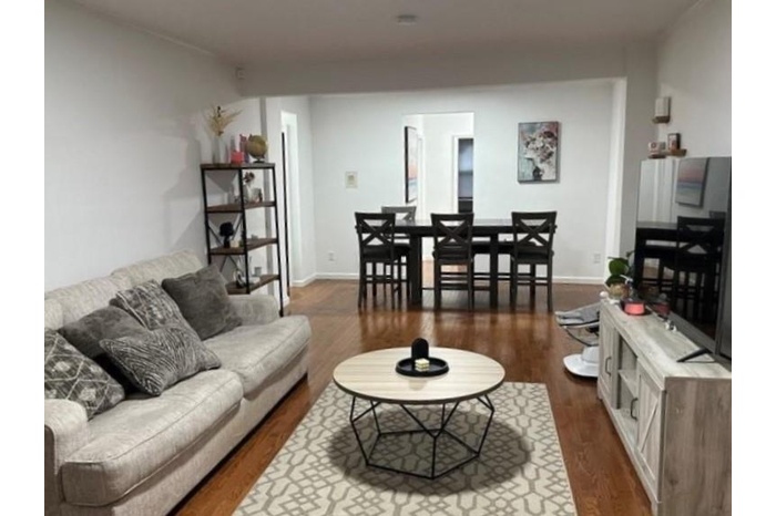 Living area featuring dark wood-style floors and baseboards