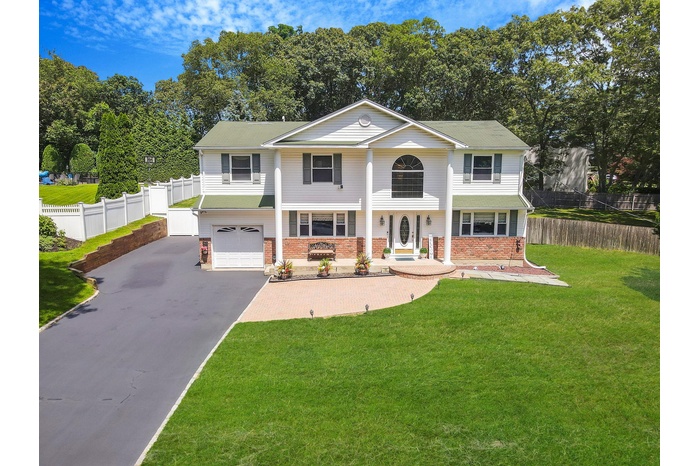View of front of house with asphalt driveway, a garage, brick siding, and a porch