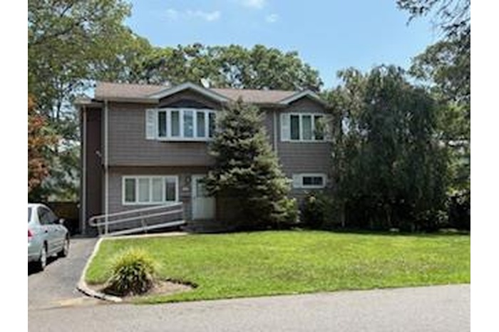 View of front of house with a front yard and asphalt driveway