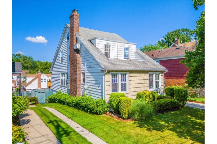 Bungalow-style home featuring roof with shingles and a chimney