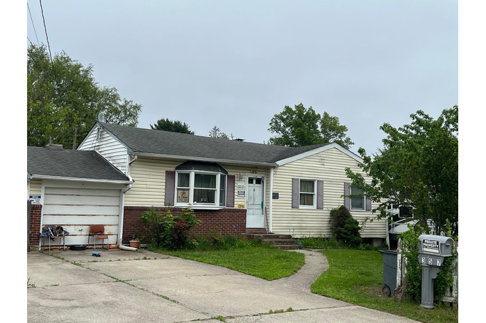 View of front facade featuring driveway, an attached garage, brick siding, a front lawn, and a shingled roof