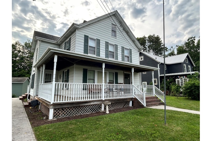 Farmhouse inspired home with a porch and a front yard