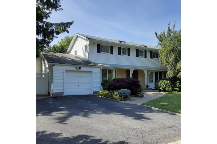 View of front facade with a garage, driveway, and a porch