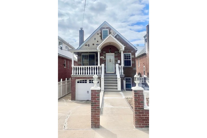 View of front of house with driveway, fence, a porch, a garage, and brick siding