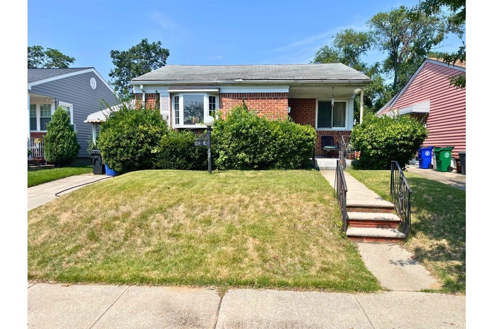 View of front facade featuring a front lawn and brick siding