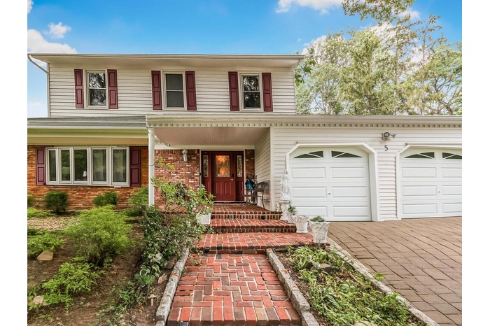 View of front of home featuring a garage, brick siding, and driveway