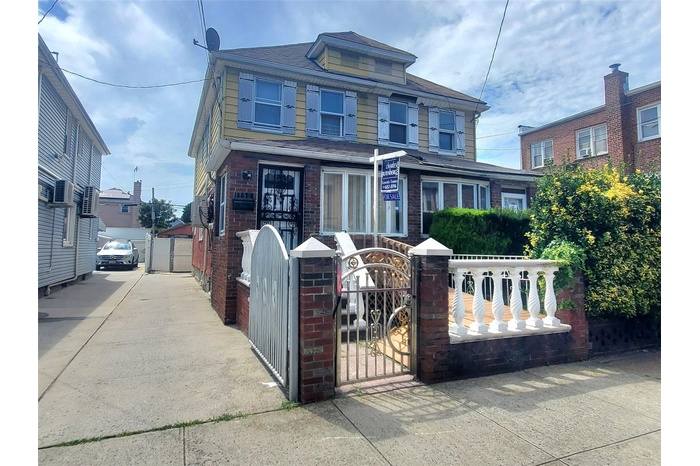 Traditional style home with a fenced front yard, brick siding, and a gate