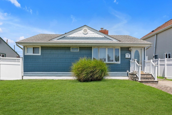 View of front of house with a shingled roof and a chimney