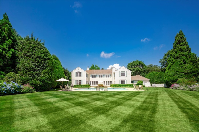 Back of house featuring a patio, an outdoor pool, a chimney, and french doors