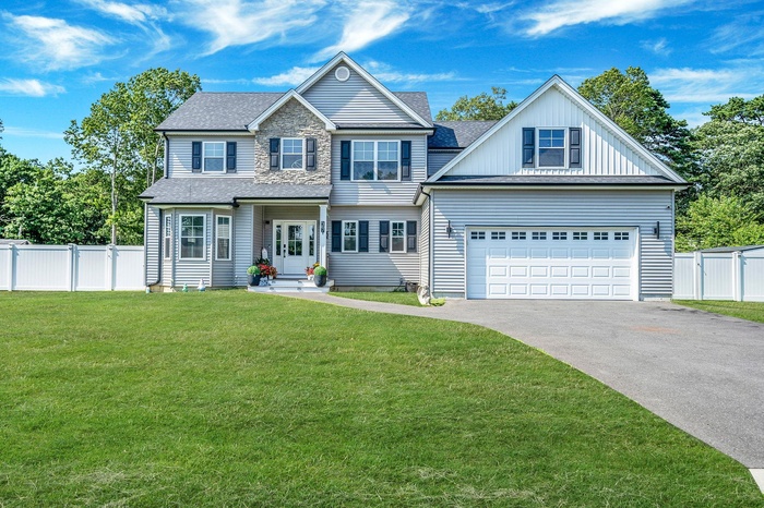 View of front facade with driveway and roof with shingles