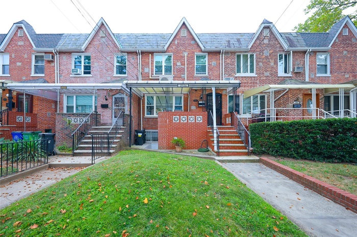 View of front of property featuring brick siding, a front yard, and a high end roof