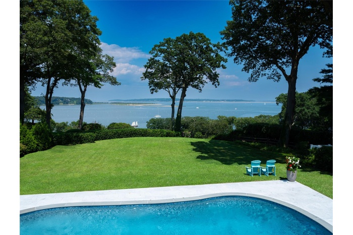 Swimming pool featuring a water view and a yard