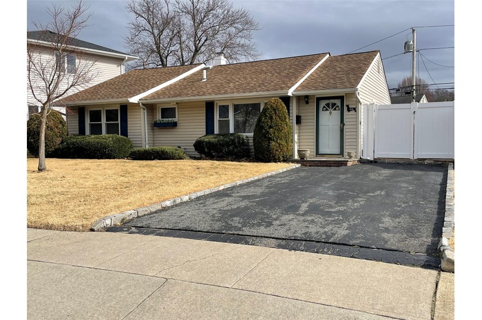 View of front of home with a gate and roof with shingles