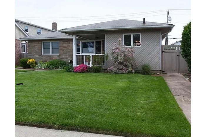 View of front of house with a front lawn and a gate