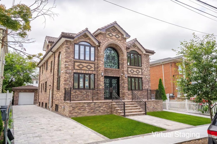 View of front of property featuring an outdoor structure, a tile roof, decorative driveway, brick siding, and french doors