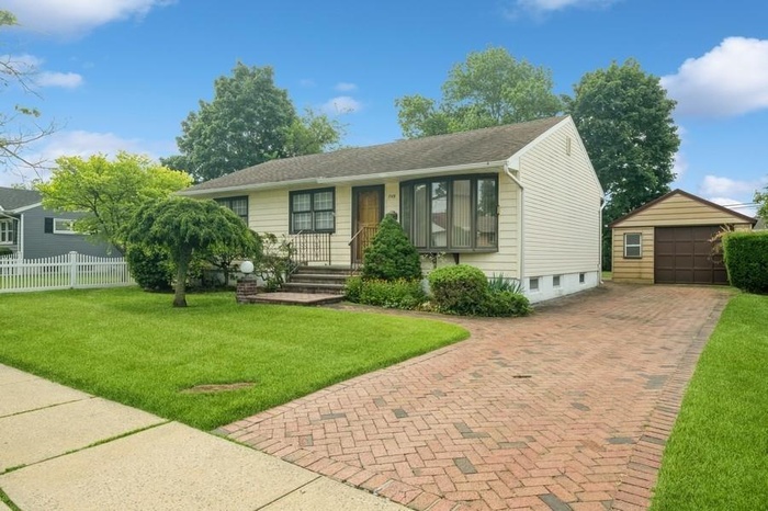 View of front of house with an outbuilding, decorative driveway, and a garage