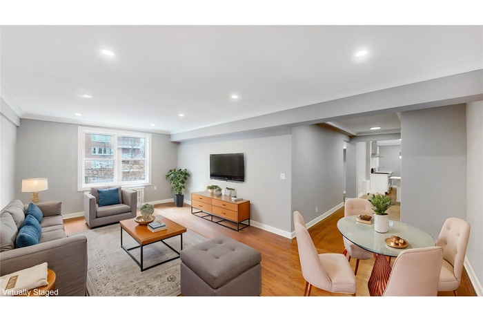 Living area featuring light wood-style flooring, crown molding, and recessed lighting