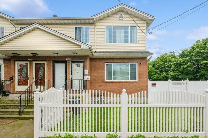 View of property featuring brick siding and a fenced front yard