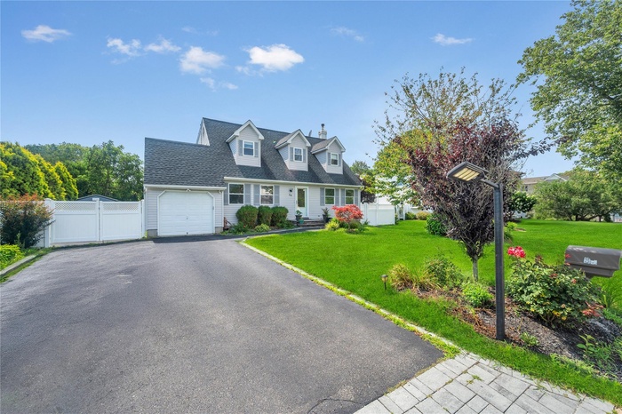Cape cod-style house with an attached garage and driveway