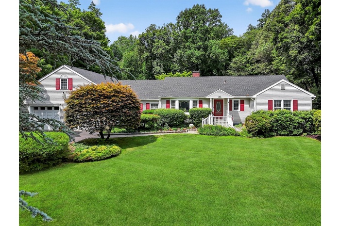 Ranch-style house featuring a front lawn, a chimney, a garage, and a shingled roof