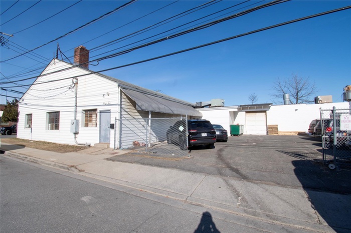 View of front of property with a chimney and uncovered parking