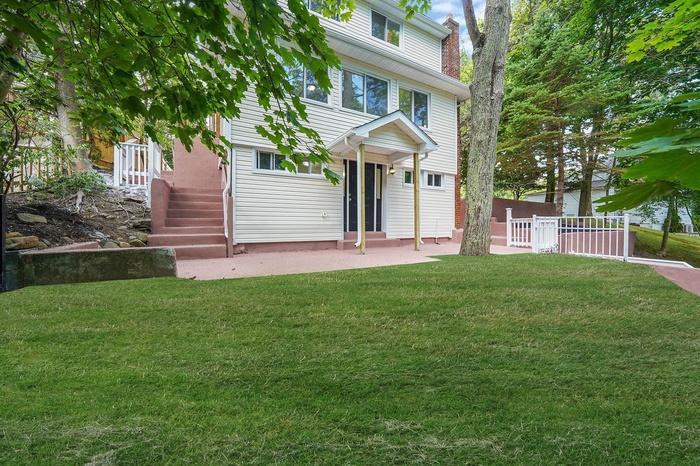 View of front of house with entry steps and a patio area