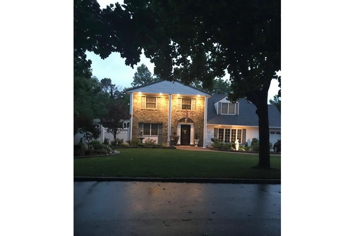 View of front of house with stone siding and a front lawn