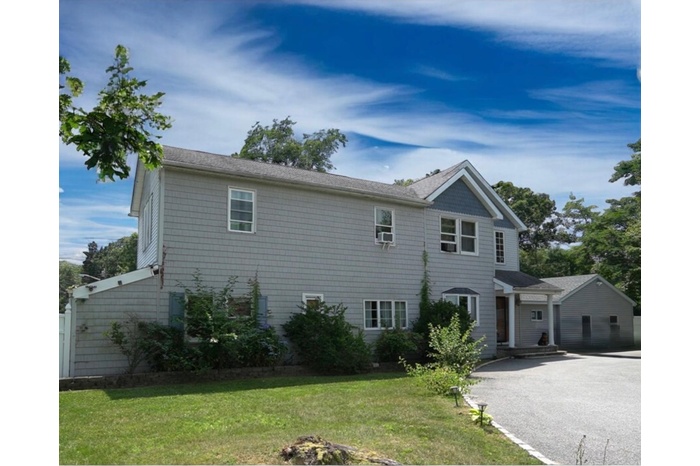 View of front of home featuring a front lawn and asphalt driveway