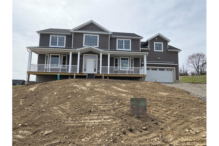 View of front of house featuring a porch, a garage, and driveway