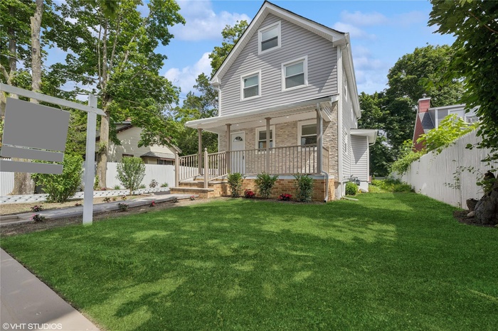 American foursquare style home with covered porch and brick siding