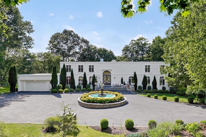 Mediterranean / spanish house featuring curved driveway, stucco siding, an attached garage, and french doors