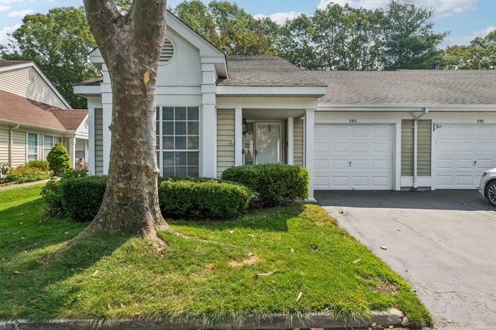 View of front of property featuring a garage, a front yard, driveway