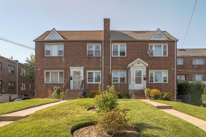 Traditional home featuring a front lawn, brick siding, and a chimney