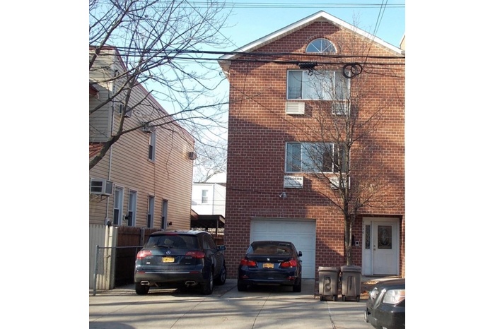 View of property featuring an attached garage and concrete driveway