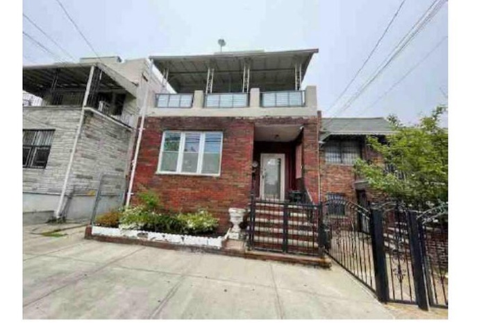 View of front facade featuring brick siding and a gate