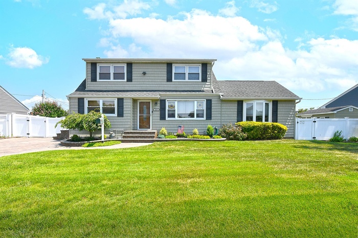 View of front of home with a gate and a shingled roof