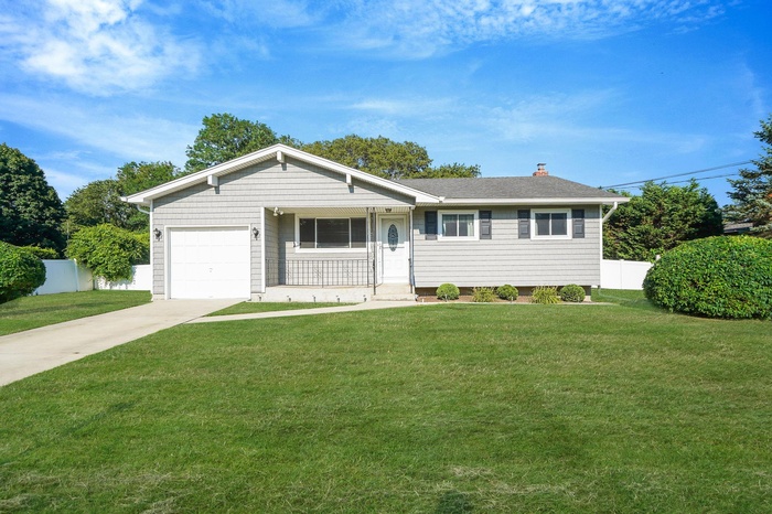 Ranch-style home with a garage, driveway, and a chimney