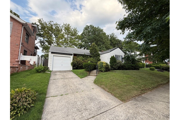 View of front of home with driveway and a front yard