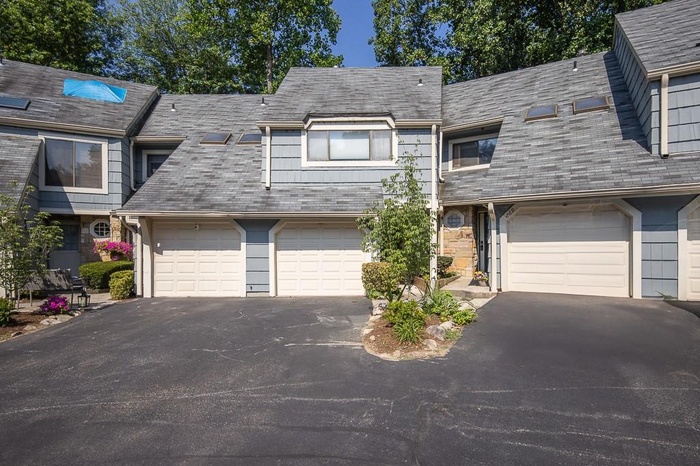 View of front of house with an attached garage and asphalt driveway