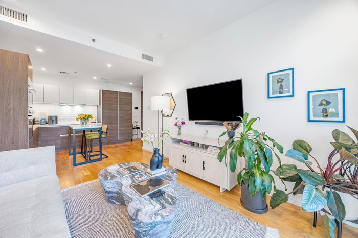 Living room with light wood finished floors and recessed lighting