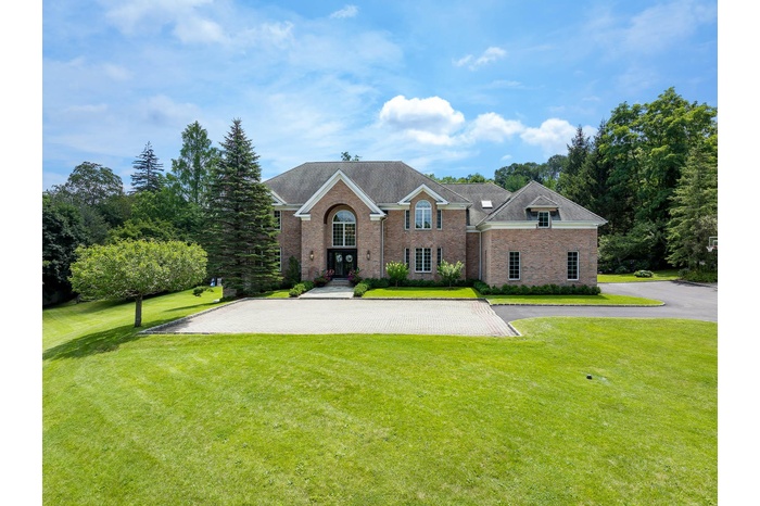 View of front of property featuring french doors, brick siding, a front yard, and a shingled roof