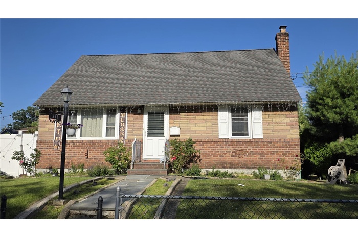 Bungalow-style house featuring a chimney, a shingled roof, and brick siding