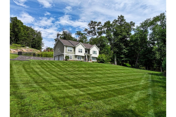 View of front of property with a garage and a front yard