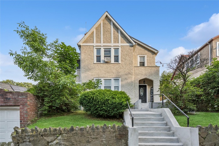 Tudor house with stucco siding and a front lawn